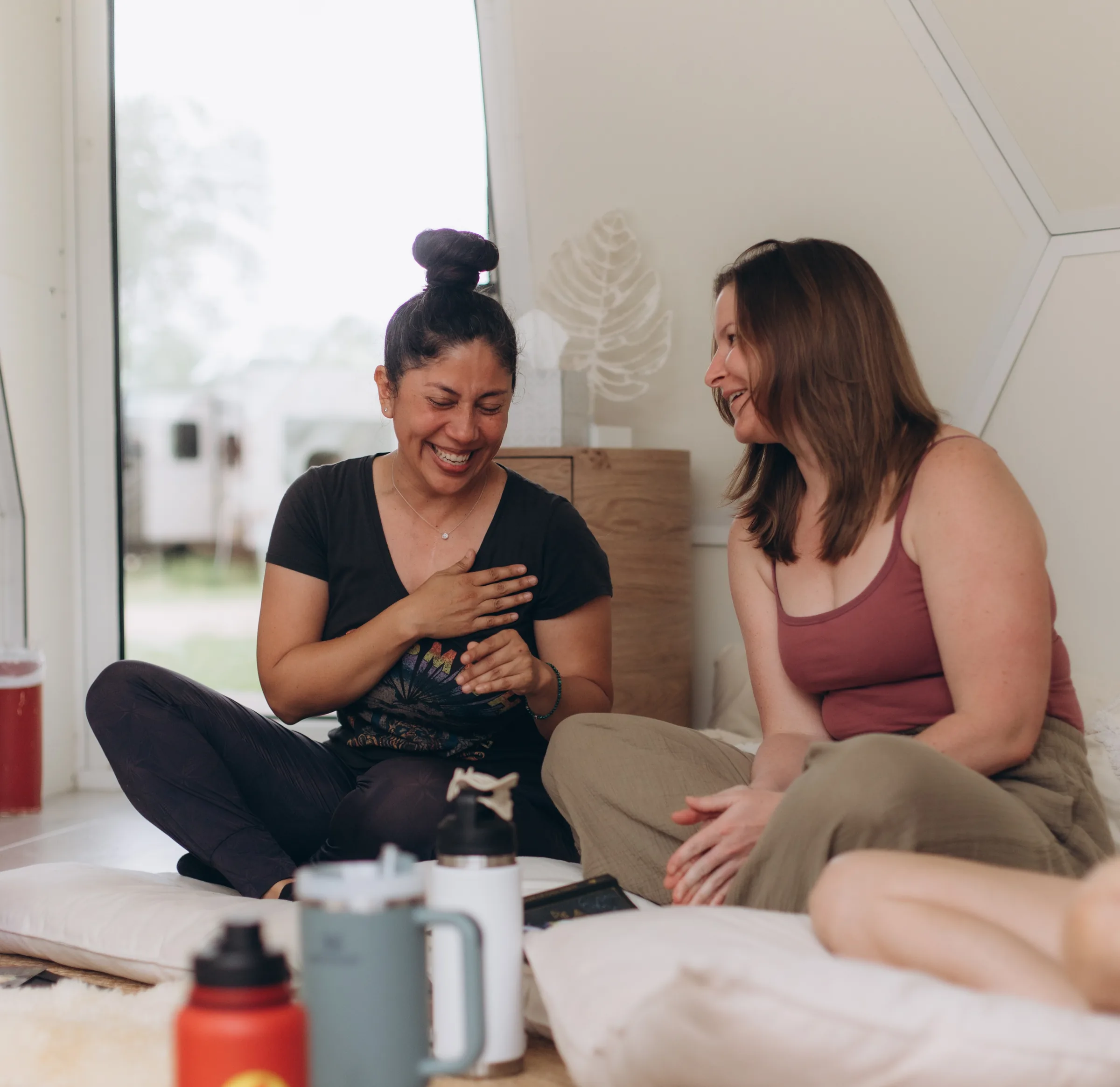 Two women laughing together after a session